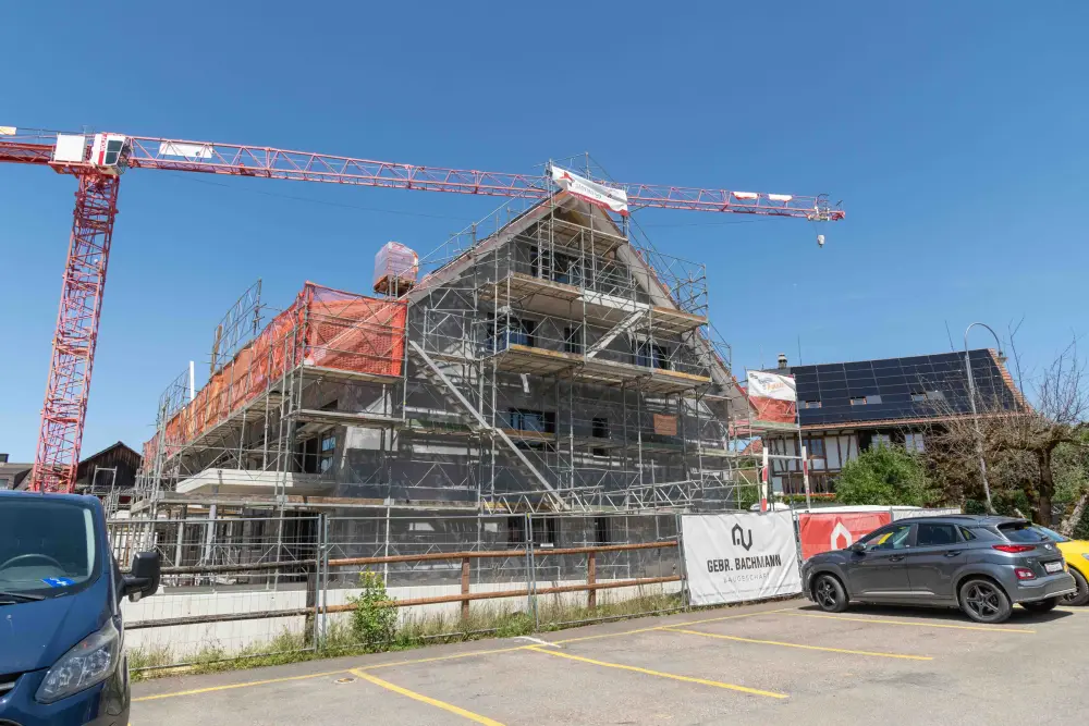 Eingerüsteter Neubau mit zwei Kranen im Hintergrund