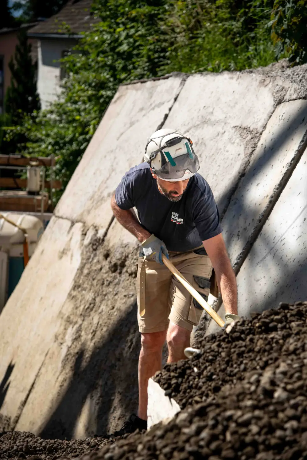 Mitarbeiter bei Arbeiten an einer Betonböschung über der Hinterfüllung