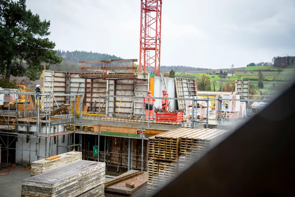 Rohbau mit Kran, Schalungsmaterial und Baustelleninstallation