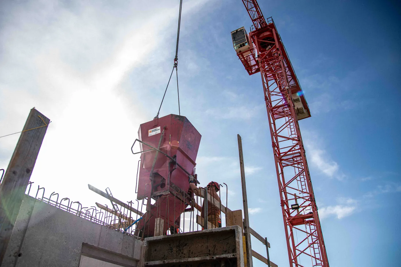 Betonkuebel am Kran ueber der Baustelle